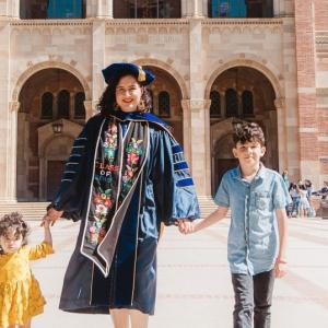 Three people in front of a building