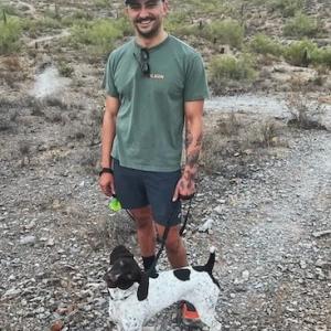 Adam Sandoval with his dog on a hike.