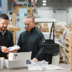Two people inspecting a product in a delivery.