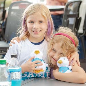 Two children at the Night of Baseball holding Aflac Ducks.