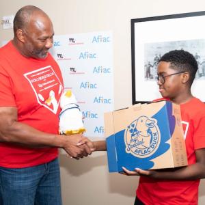 Aflac Senior Vice President of Federal Relations Brad Knox delivers a My Special Aflac Duck to 10-year-old sickle cell patient Kendric Comer at Nationals Park in Washington, D.C. Aflac treated sickle cell patients from Children's National Hospital to a day at the ballpark to commemorate World Sickle Cell Day on June 19.    