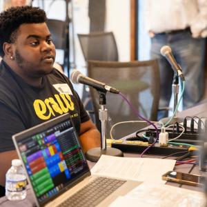 Cyronn shown being interviewed on a radio broadcast.