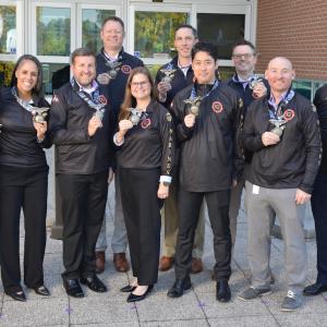 Aflac team members show their medals from the Marine Corps Marathon.