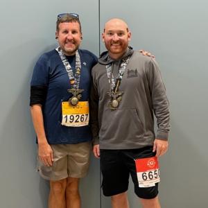 Two Aflac Team Members shown with their medals from the Marine Corps Marathon.