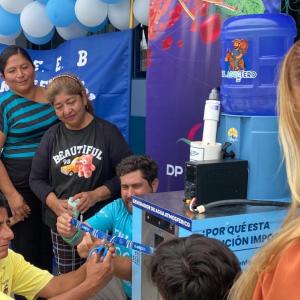Community members gather around an atmospheric water generator during a ribbon-cutting event for DP World’s El Aguatero clean water initiative in Ecuador.