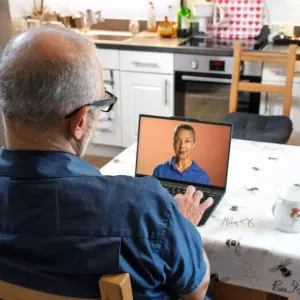 A person sat at a table using a laptop