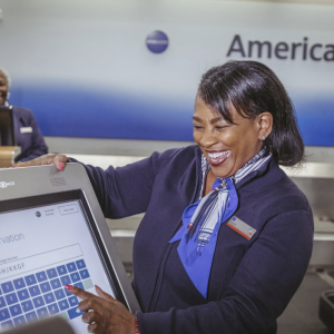 An airport staff member looking up a reservation on a screen 