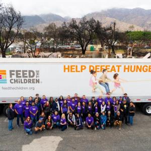 Group picture of volunteers in front of Feed the Children Truck