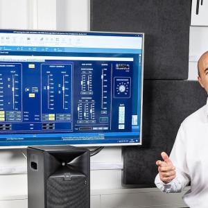 Alessandro shown in front of a monitor with a schematic.