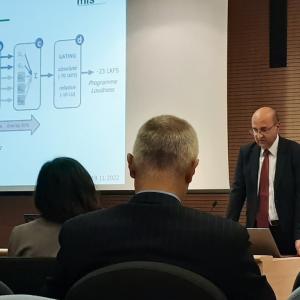 Alessandro shown addressing a group with a presentation.