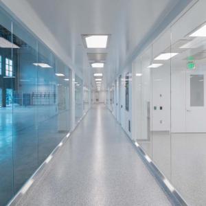 A long hallway with windowed walls, one side blue-tinted.