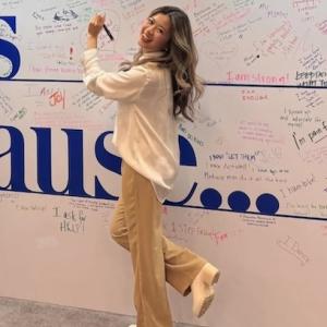 Amanda Kwong shown writing on a wall.