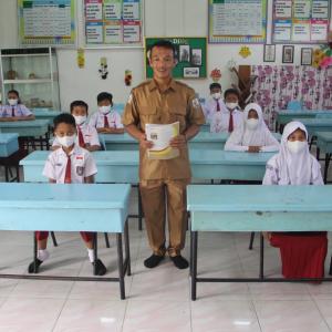 Teacher standing among students in desks
