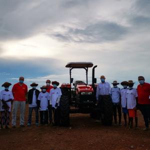group standing around donated tractor