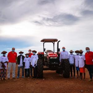 group standing around donated tractor
