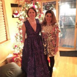 Anna Compesi and another person, a lit Christmas tree behind them