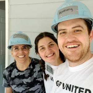 Anthony Reyna & wife at GP Build with Erin Beckman in front of a house.