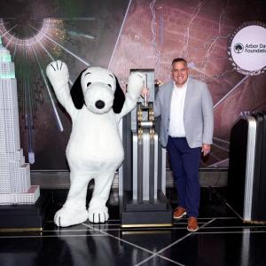 Arbor Day Foundation CEO Dan Lambe and Snoopy flip the switch the light the Empire State Building green.