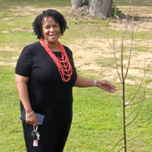 Woman next to a young tree