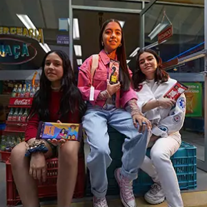 Three girls holding Hershey bars with "Her" and "She" highlighted on the wrappers