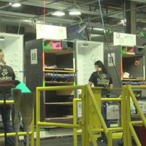 three workers assembling refrigerators 