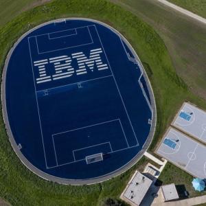 Aerial view of an athletics field, IBM in large print on the blue court.