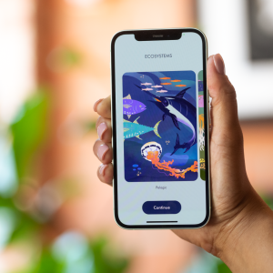 A hand holding a phone open to the Aurelia app. Sea creatures on the screen.