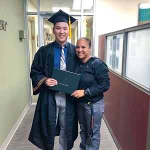 Austin stood next to someone in a graduation gown and cap 