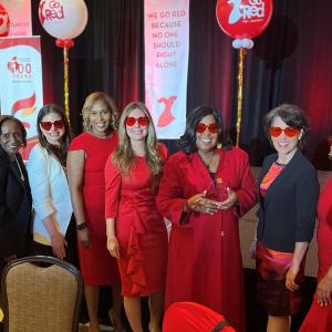 A group of people posed, each wearing red sunglasses.