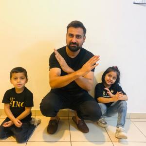 Man and two children in black t-shirts crossing their arms