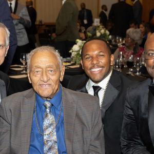 four people in suits and ties at a fancy banquet