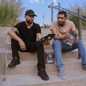 2 men sit on stairs viewing bags of BLK & Bold Coffee