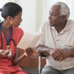 Female black doctor consulting with a male, black patient.