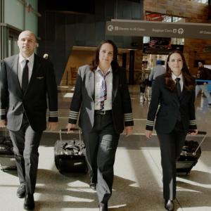 Three pilots walking through an airport with their suitcases 