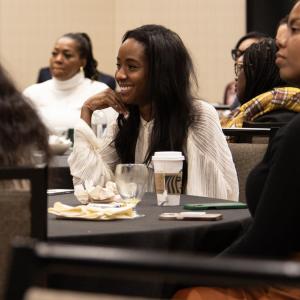A smiling participant seated in a room of others