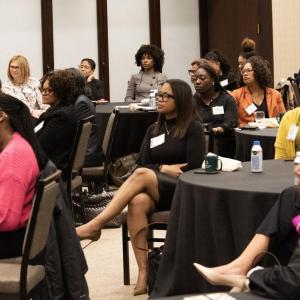 A room full of seated participants listening to a speaker