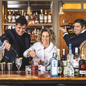 3 Bartenders smile while making drinks