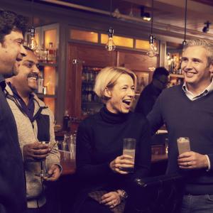 4 people enjoy drinks at a bar