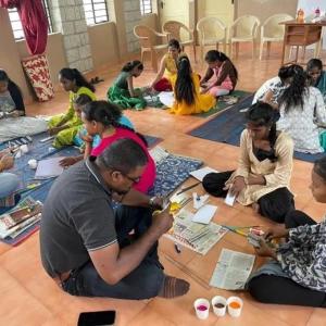 People sat on the floor painting 