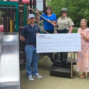 People posing with check at playground