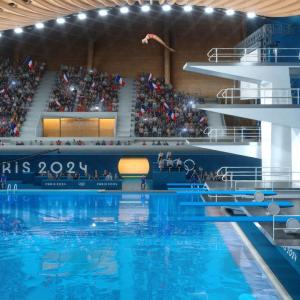 olympic athlete diving off a high platform into a pool