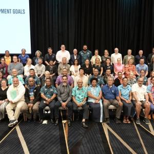 diverse group of people sitting and standing in 4 rows on a convention stage