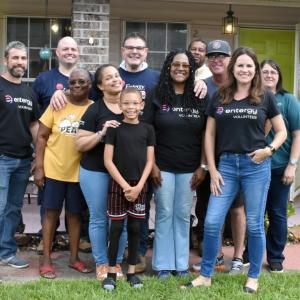 A group of people posed outside a home.