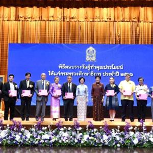 A line of people on a stage, holding certificates.