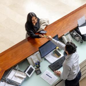 Aerial view of woman paying for hotel stay at front desk
