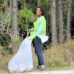 A volunteer smiles as she participates in the Fort Morgan clean-up.