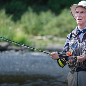 Bill Nye in a river fly fishing
