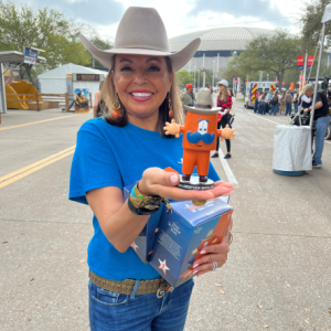 Angela Cole holding a bobble head out of the box.