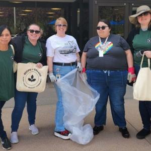 A group of people standing outside with trash bags