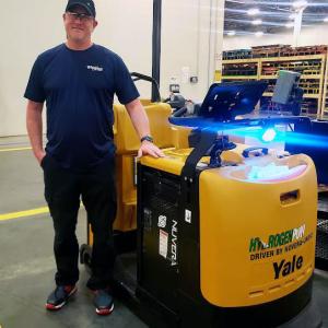 Brian Ross standing by a forklift